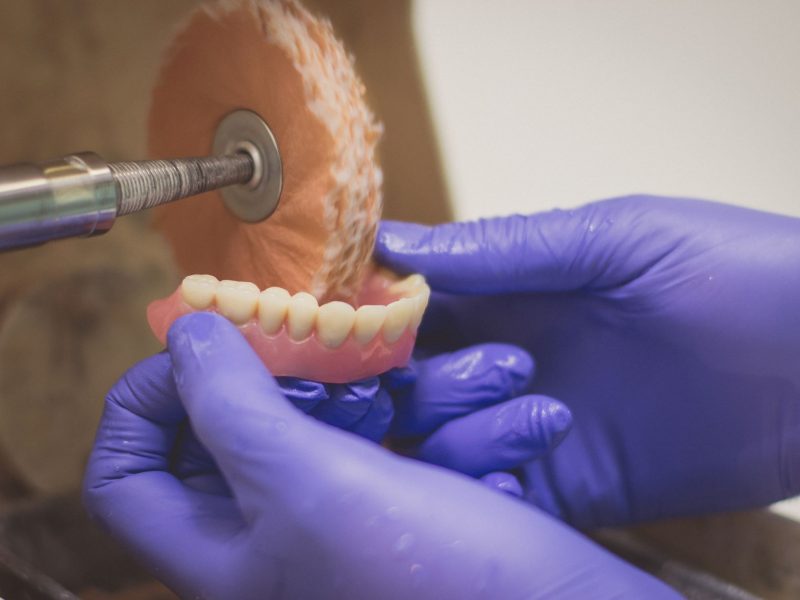 Denture being processed by tool