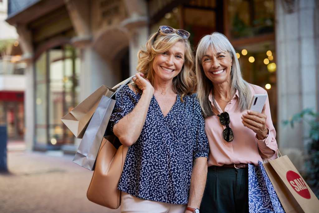 two mature women smiling after shopping
