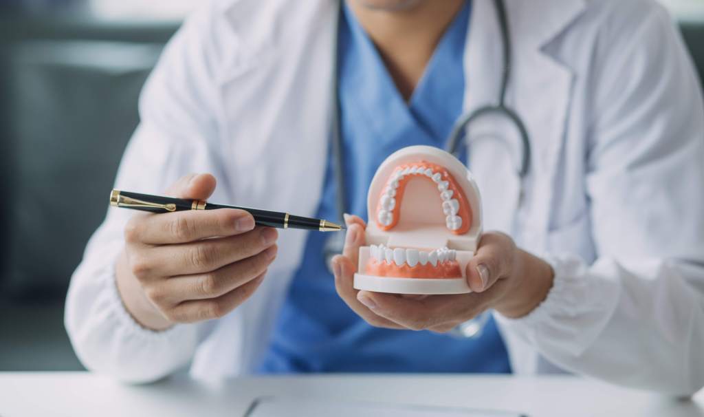 dentist holding and explaining dentures